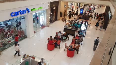 View-of-a-shopping-center-with-people-walking,-entering-and-leaving-the-stores