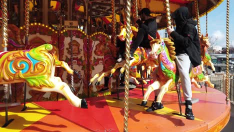 Slow-motion-view-of-Sicocks-fair-carousel-rotating-colourful,-Illuminated-horses-riding-on-poles