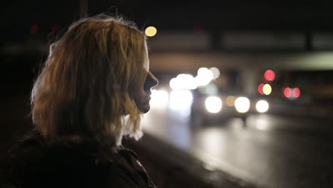 A-girl-stands-by-a-highway-at-night