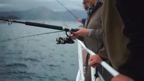 SLOWMO---Group-of-fishermen-with-rods-fishing-off-boat