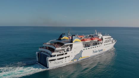 Aerial-panoramic-shot-Island-crossing-ship-leaving-from-dock-full-of-tourists