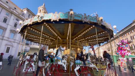 Gente-Montando-El-Antiguo-Carrusel-De-Caballos-Alemán-Frente-A-Sant&#39;agnese-In-Agone,-Piazza-Navona-En-Roma,-Italia