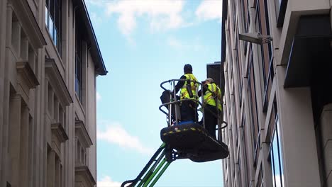 Ascensor-Con-Constructores-Subiendo-Entre-Edificios