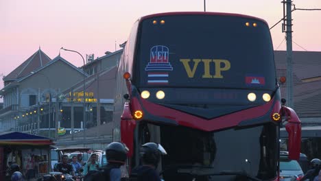 Medium-Shot-of-Big-Red-Bus-Turning-A-Corner-among-Traffic-at-Rush-Hour-on-a-Busy-Road