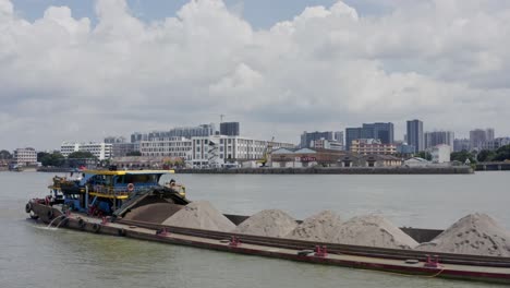 Buque-Fluvial-Chino-Completamente-Cargado-Con-Carga-A-Granel-De-Arena-En-Marcha-En-El-Río-Zhujiang,-En-Un-Día-Nublado