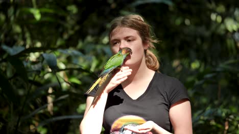 Loro-Verde,-Loro-Conure-De-Garganta-Azul-Sentado-En-La-Mano-Humana-Y-El-Loro-Volador-Libre-De-La-Cabeza-Sentado-Sentado-En-El-Loro-Volador-Humano-Libre-Jugando-Con-Una-Niña