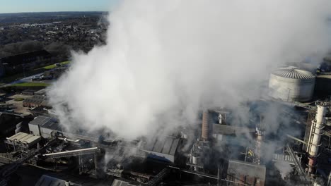 Flying-through-the-steam-and-above-the-British-Sugar-factory-in-Bury-St-Edmunds,-Suffolk