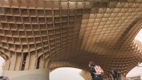 Walking-up-stairs-of-landmark-Setas-monument-in-Seville,-Spain,-TILT-UP