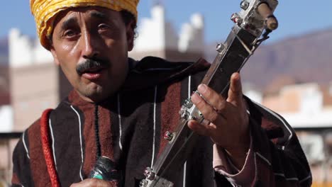 Músico-Bereber-Mirando-A-La-Cámara-Mientras-Toca-Rabab-Y-Canta-En-Taffraoute,-Marruecos