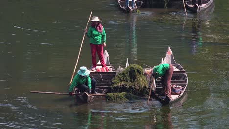 Mittlere-Aufnahme-Asiatischer-Damen-In-Booten,-Die-Den-Wassergraben-Um-Angkor-Wat-In-Kambodscha-Reinigen