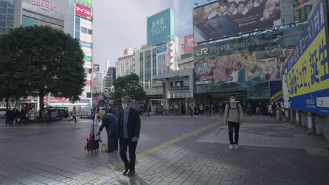 Menschen,-Die-Während-Covid-19-Vor-Dem-Shibuya-Bahnhof-In-Der-Nähe-Des-Shibuya-Kreuzes-In-Tokio,-Japan,-An-Einem-Als-Donald-Trump-Verkleideten-Mann-Vorbeigehen-Und-Vorbeigehen