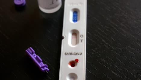 Nahaufnahme-Des-Schnellen-Antigen-Covid-Testkits,-Der-Lanzette-Und-Der-Pufferlösung,-Die-Ein-Negatives-Ergebnis-Zeigt