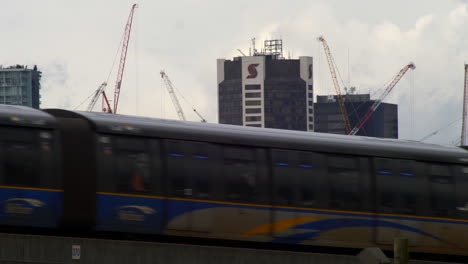 Große-Baustelle-Mit-Vielen-Kränen-Zwischen-Der-Innenstadt-Von-Vancouver,-Während-Im-Vordergrund-Ein-Transitzug-Vorbeifährt