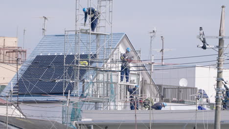 Bauarbeiter-Mit-Sicherheitsausrüstung-Arbeiten-Auf-Gerüsten-Vor-Einem-Haus