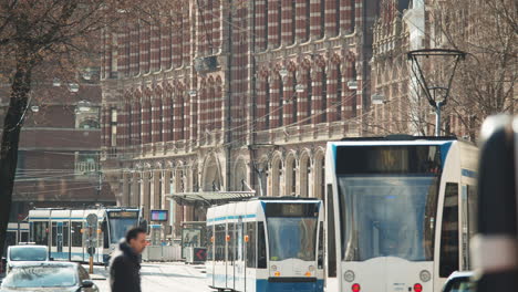 Trams-And-Vehicles-Travelling-At-City-And-Passing-By-Shopping-Mall-Of-Magna-Plaza-In-Amsterdam,-Netherlands