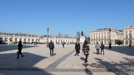 Menschen-Mit-Gesichtsmasken,-Die-An-Einem-Sonnigen-Tag-Am-Place-Stanislas-Spazieren-Gehen