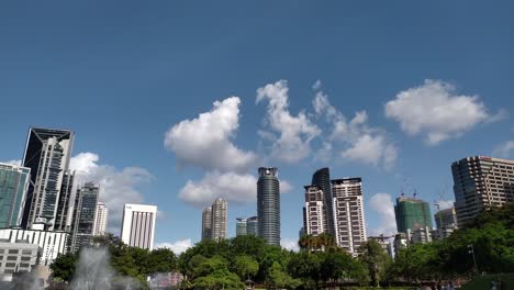 Zeitraffervideo-Der-Springbrunnenshow-Im-KLCC-Park-Mit-Geschäftsgebäude-Und-Turm-Im-Hintergrund-Mit-Strahlend-Blauem-Himmel