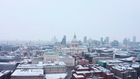 Absteigende-Luftdrohnenaufnahme-Der-St.-Pauls-Cathedral,-Die-Die-Stadt-London-Schneit