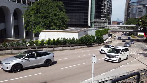 Traffic-passing-in-downtown-Hong-Kong,-Low-angle-aerial-view