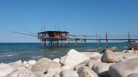 Turistas-En-La-Playa-De-Costa-Dei-Trabocchi-Con-Trabocco-O-Trabucco-En-Segundo-Plano