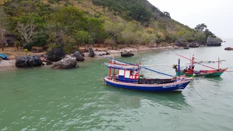 Aerial-footage-of-Asian-Fisherman-boats-anchored-of-the-coast-of-Khao-Ta-Mong-Lai-Bay,-South-of-Thailand