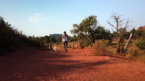 Mujer-Caminando-Mascota-Perro-Maltés-En-El-Sendero-Del-Desierto-De-Sedona