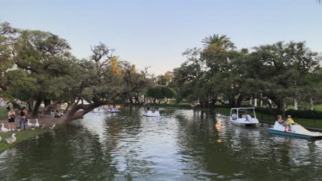 Lufttransportwagen-Aus-Booten,-Die-Bei-Sonnenuntergang-Im-Rosedal-Gardens-Pond-Im-Viertel-Palermo,-Buenos-Aires,-Segeln