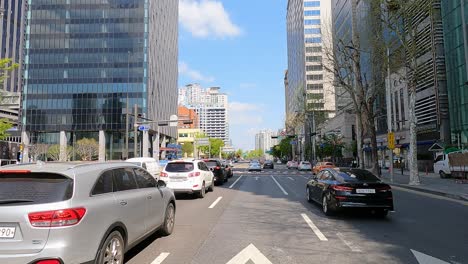 El-Punto-De-Vista-Del-Conductor-Conduce-Y-Viaja-En-La-Ciudad-Con-Vistas-A-Un-Edificio-Alto-Y-Un-Rascacielos-En-El-Distrito-De-Jamshil-En-Seúl,-Corea-Del-Sur