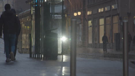 Tram-stop-in-downtown-street-of-a-big-city-on-a-snowy-day