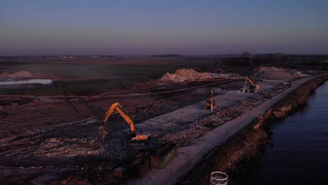 Aerial-View-Of-Excavators-Working-At-Construction-Site-On-The-Riverbank-Of-Noord-River-In-South-Holland,-Netherlands