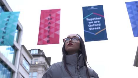 Beautiful-young-woman-looks-around-her,-Soho,-London,-UK,-low-angle-medium-shot