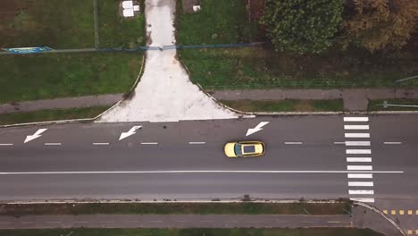 Vista-Superior-Aérea-De-Un-Coche-Insignia-De-Opel-Amarillo-En-Una-Carretera-De-La-Ciudad