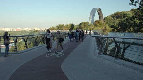 People-walk-across-the-glass-bridge-in-Kiev-on-a-warm-autumn-evening