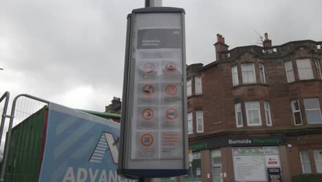 A-close-up-shot-of-a-bus-stop-sign-with-coronavirus-advice-on-it