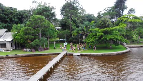 Aerial-Pan-Drone-Footage-of-Yoga-Practitioners-on-Nature-Lake-in-Florianopolis,-Brazil