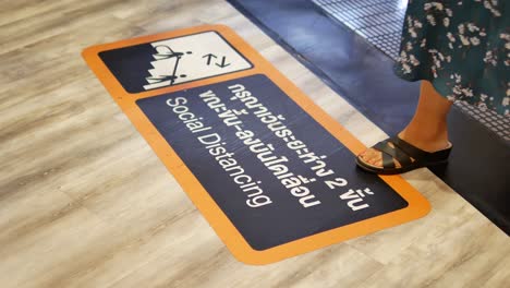 Close-Up-Footage-of-Social-Distancing-Warning-Signboard-on-The-Shopping-Mall-Floor