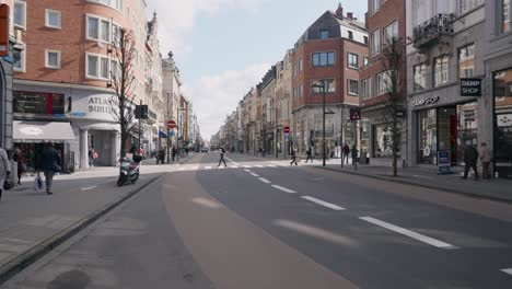 Menschen-Mit-Masken-An-Der-Einkaufsstraße-Bondgenotenlaan-In-Leuven-An-Einem-Sonnigen-Tag-Während-Der-Belgischen-Koronapandemie