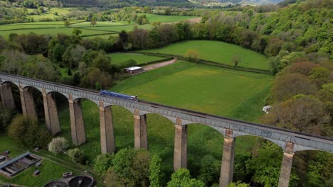 Vista-Aérea-Siguiendo-Un-Barco-Estrecho-En-La-Cuenca-De-Trevor,-Cruce-Del-Acueducto-Pontcysyllte-En-El-Campo-Del-Valle-Galés-Que-Se-Eleva-Hacia-Arriba,-Se-Inclina-Hacia-Abajo