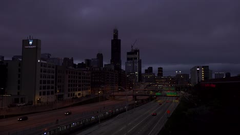 Autos-Und-U-Bahnen-Fahren-Unter-Dunklen-Wolken-An-Der-Skyline-Der-Stadt-Vorbei