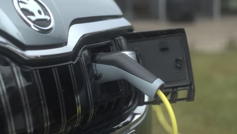 Close-up-shot-of-person-Unplugging-In-Hybrid-Car-At-Electro-Charging-Station