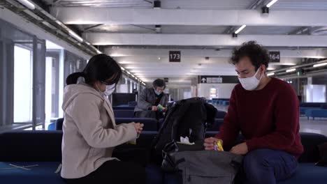 Pareja-Con-Mascarillas-Sentada-En-El-Aeropuerto-Durante-La-Crisis-De-La-Corona