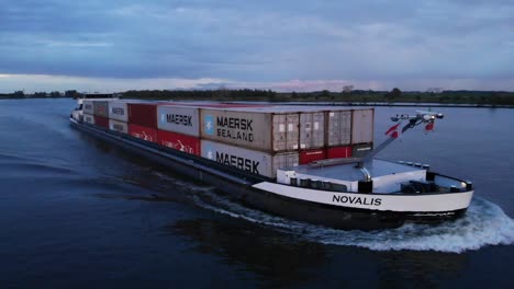 Novalis-Inland-Vessel-Carrying-Stack-Of-Container-Ship-Travelling-At-Oude-Maas-River-In-Netherlands