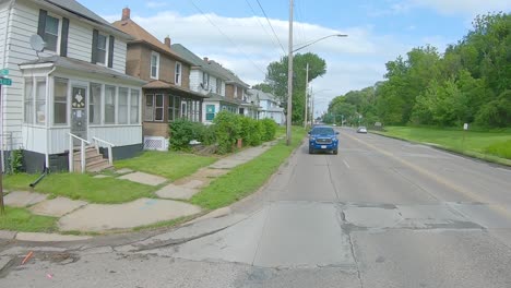 Punto-De-Vista-De-La-Ventana-Trasera-Mientras-Conduce-Por-Una-Carretera-De-Cuatro-Carriles-En-Un-área-Suburbana-En-El-área-Metropolitana-Del-Medio-Oeste