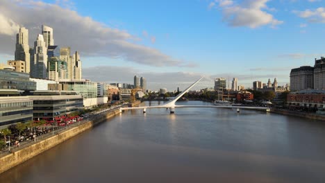 Vista-Aérea-Volando-Hacia-El-Puente-De-La-Mujer-En-El-Paseo-Marítimo-De-Puerto-Madero,-Buenos-Aires