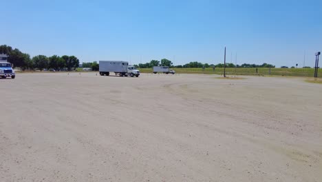 Student-learning-how-to-maneuver-a-semi-tractor-and-trailer-backwards-into-a-parking-spot-in-a-large-empty-lot