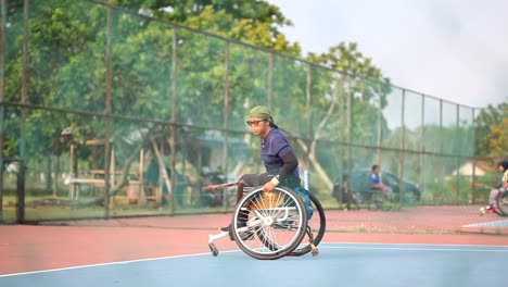 Yogyakarta,-Indonesia---2-De-Mayo-De-2021:-Hombre-Asiático-En-Silla-De-Ruedas-Jugando-Tenis-En-La-Cancha