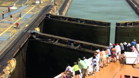 Turistas-En-La-Proa-De-Un-Crucero-Observando-El-Proceso-De-Tránsito-De-Las-Esclusas-De-Miraflores,-Canal-De-Panamá