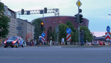 FIA-European-Rally-Trophy-2021-festive-start-and-cars-parade-at-streets-of-Liepaja-,-rally-cars-passing-spectators,-low-angle-tracking-shot-right