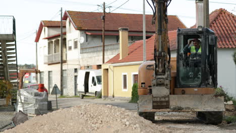 Máquina-Cargadora-Excavadora-Moviéndose-Hacia-El-Montón-De-Grava-Durante-Las-Obras-Viales-En-Un-Pueblo-En-Leiria,-Portugal