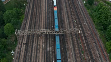 Schwenk-Drohnenaufnahme-Von-Weitläufigen-Eisenbahnschienen-Zur-Skyline-Von-London